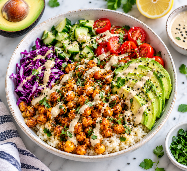 Crispy chickpea avocado bowl with rice, fresh vegetables and lemon tahini sauce